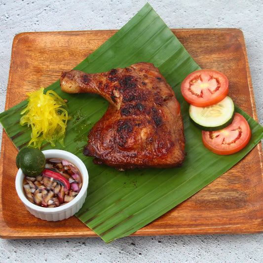 Chicken inasal quarter on a banana leaf