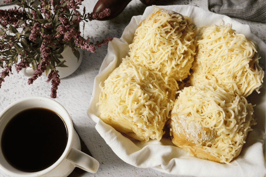 A white plate featuring slices of cheese, highlighting a savory element of Filipino pastries and breads.