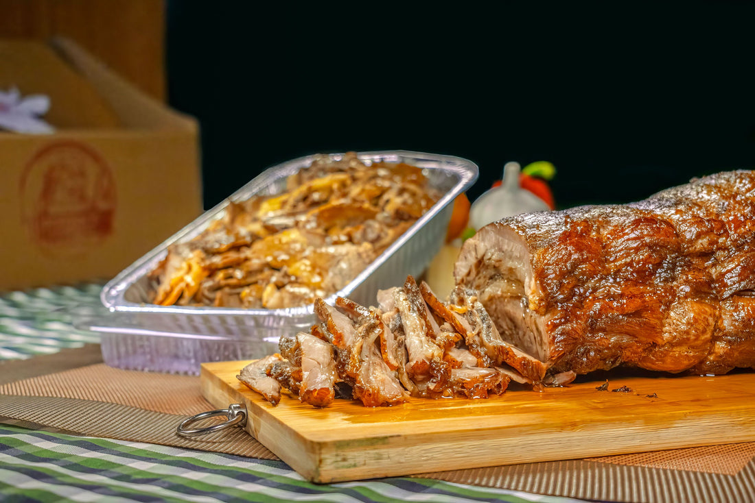 A whole roast lechon on a cutting board, surrounded by a variety of side dishes, perfect for a party feast.