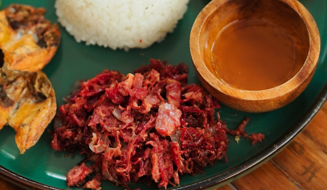 A plate featuring Filipino corned beef, rice, fried eggs, and assorted vegetables, showcasing a hearty meal.