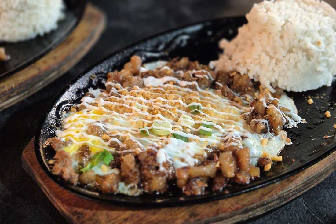 Plates of pork sisig with rice, featuring a flavorful blend of crispy pork and seasonings, ready to be enjoyed.