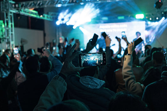 Concertgoers at a Filipino OPM event in London, joyfully raising their hands in the air amidst vibrant performances.