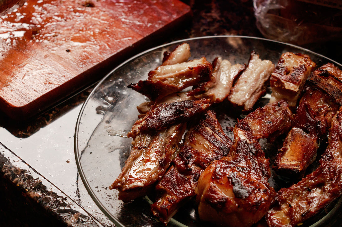 A plate of succulent ribs on a counter, showcasing the rich, caramelized exterior of the roast pork dish.