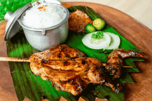  A plate featuring grilled chicken inasal served with rice, showcasing a popular Filipino dish known for its marinated flavor.