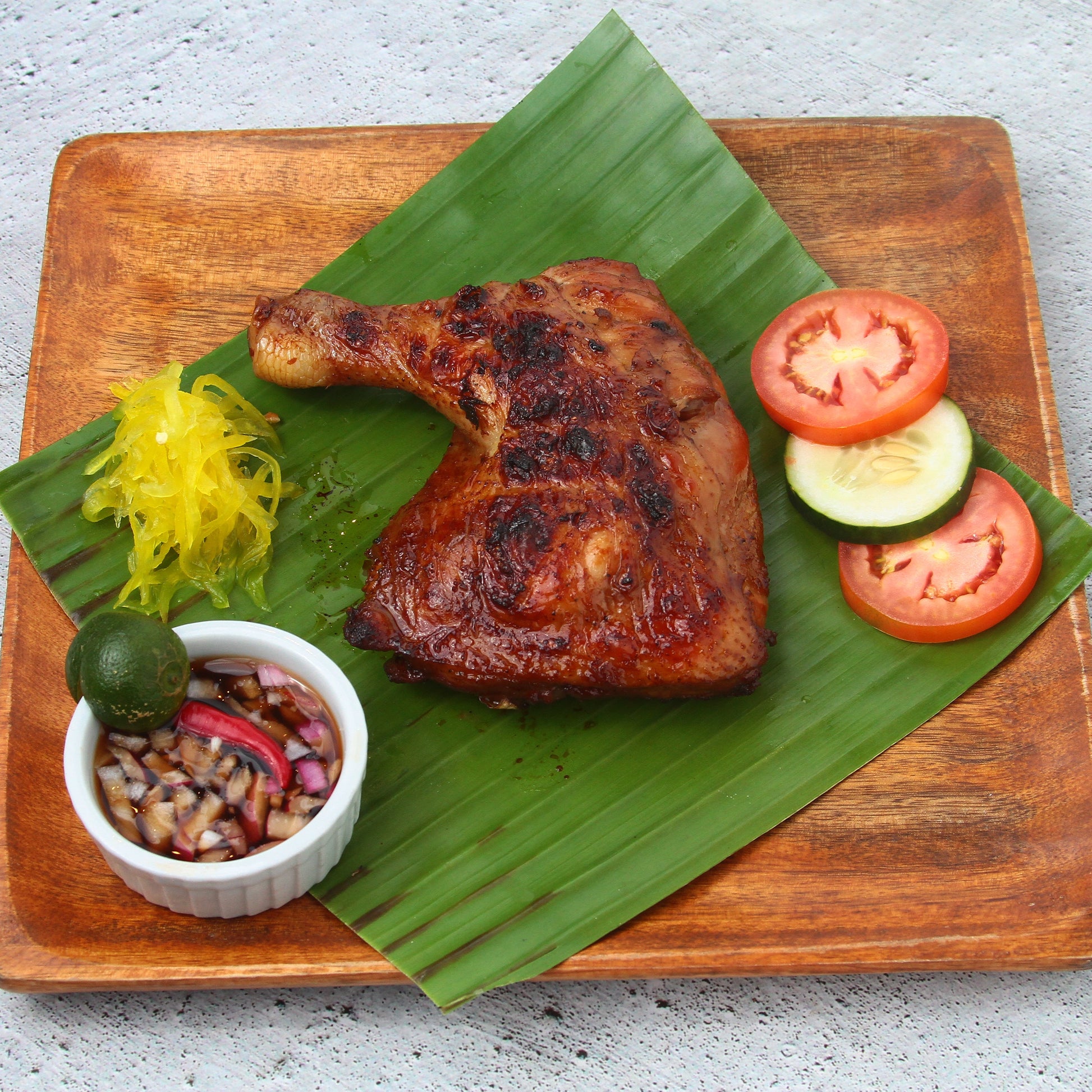 Chicken inasal quarter on a banana leaf 